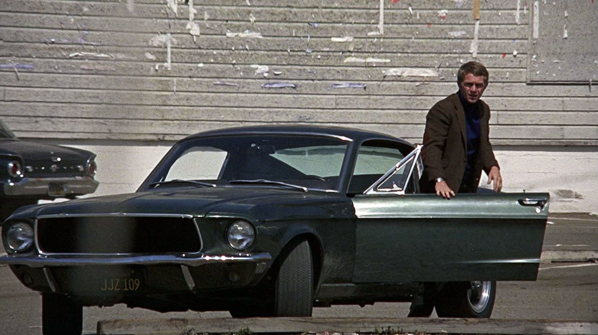 Frank Bullitt (Steve McQueen) à côté de sa Ford Mustang GT 390.